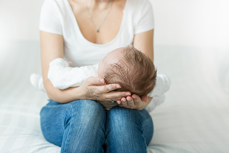 母亲和手握着睡觉的头3个月大婴儿男孩图片