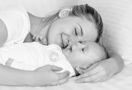 拥抱婴儿的幸福快乐母亲黑白像图片