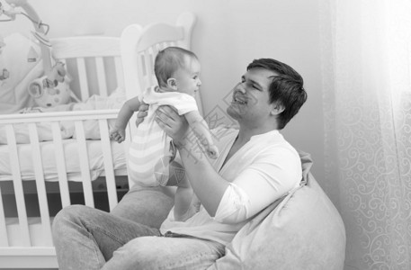 带着他六个月的宝贝儿子微笑的父亲黑色和白画像图片