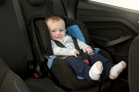 坐在汽车座椅上笑的婴儿背景图片