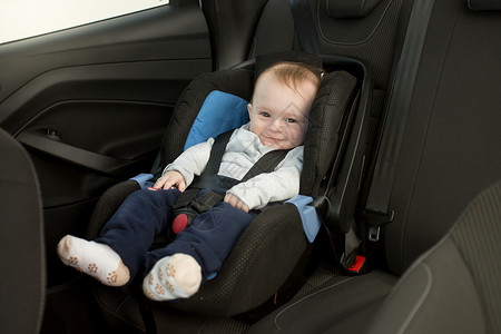 6个月大的婴儿坐在汽车座位上背景图片