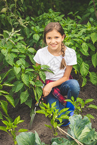 快乐的年轻女士工作在花园与四轮勺高清图片素材