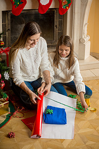 母亲和女儿一起包装圣诞礼物图片