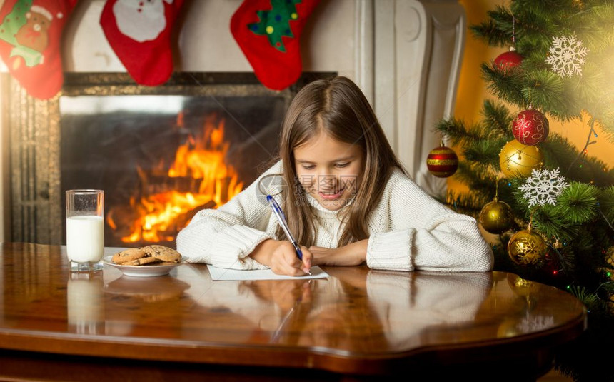 可爱的女孩在圣诞节前夕写信给圣诞老人图片
