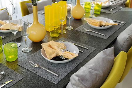 餐桌上用黄色和灰的装饰板摆着一张盘子背景图片