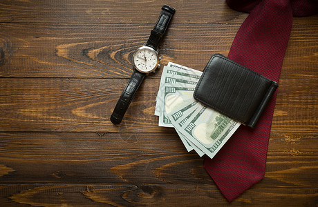 手表钱包里的黑木背景上的红领带高清图片