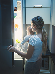 母亲和婴儿在深夜打开冰箱图片