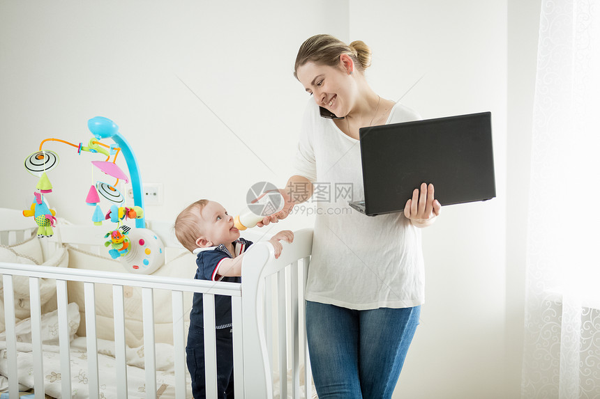 在家与婴儿一起工作的女商人图片