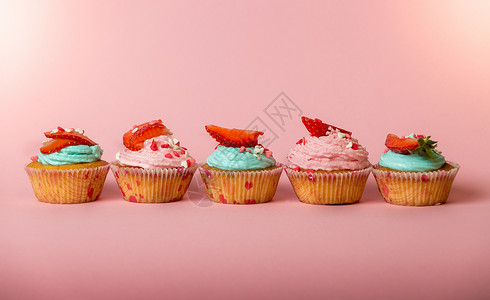 粉红和蓝色纸杯蛋糕粉红背景鲜草莓图片