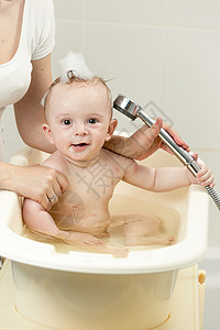 男孩洗澡和玩浴头图片