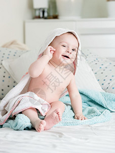 9个月大的婴儿男孩在洗澡后躺床上浴后被毛巾覆盖图片