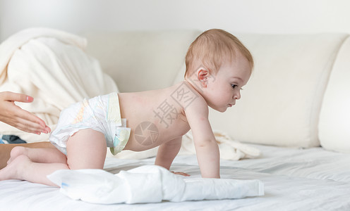 9个月大的婴儿尿布爬在床上图片