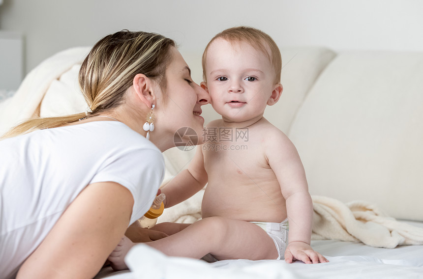 母亲在床上吻男孩的脸颊图片