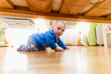 从床底下看可爱宝爬在地板上图片