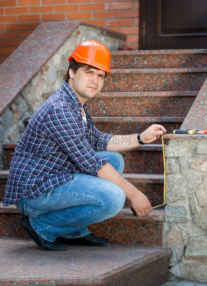 在户外测量楼梯的男工人图片