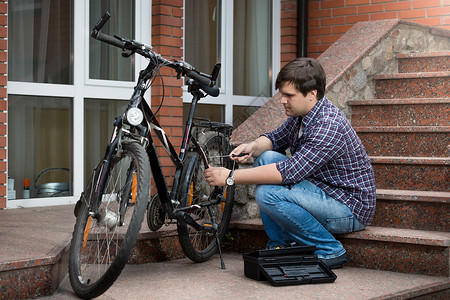 青年修理自行车后轮图片
