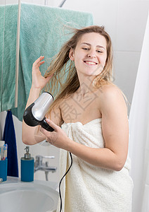 在浴室毛巾里擦发的年轻女人图片