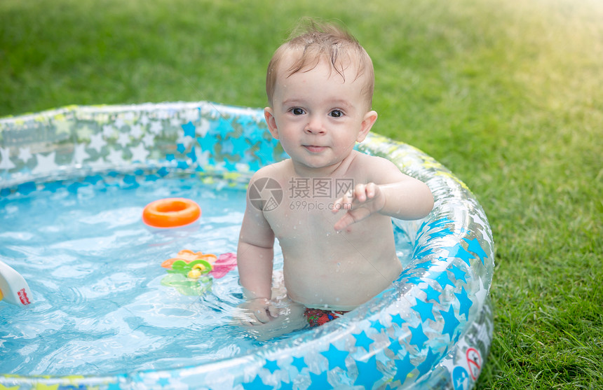 婴儿在花园的充气游泳池里玩耍图片