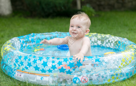 可爱9个月大的小孩男在充气游泳池玩得开心晴朗的高清图片素材