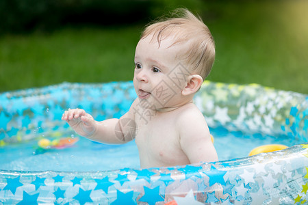 男孩在花园游泳池玩得开心图片