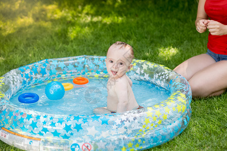 美丽的女子在游泳池里和小男孩玩得开心图片