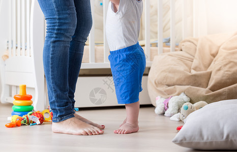 10个月大的婴儿在客厅学习如何与母亲一起走路图片