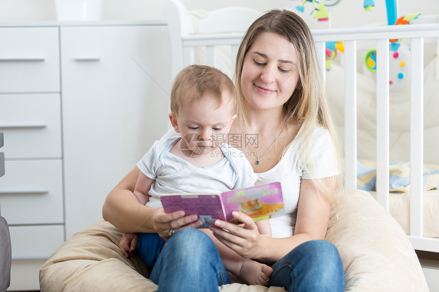 坐在母亲大腿上看书的婴儿图片