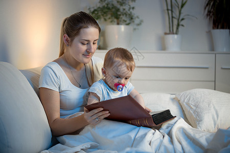 年轻母亲睡前教孩子读书图片