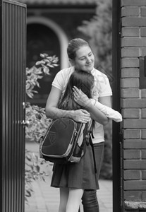 快乐的母亲和女儿放学后见面的单色照片图片