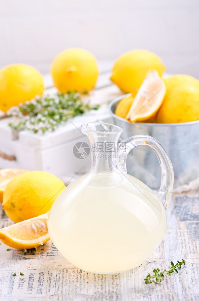 在玻璃壶和桌子上喝新鲜柠檬汁图片