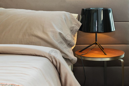 现代黑灯和床上棕色枕头图片