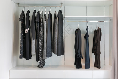 现代衣柜里有一排黑裙子挂在衣柜的架上图片