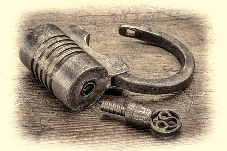古老的圆形手工艺式螺旋型铁板锁不用钥匙在生锈的木上反转手印有色书头型图片