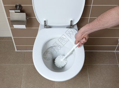 洗手间中现代白色厕所碗用洗手刷打扫图片