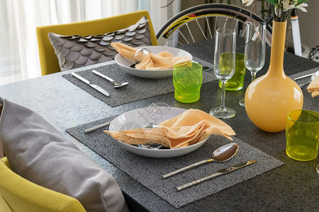餐桌上用黄色和灰的装饰板摆着一张盘子高清图片