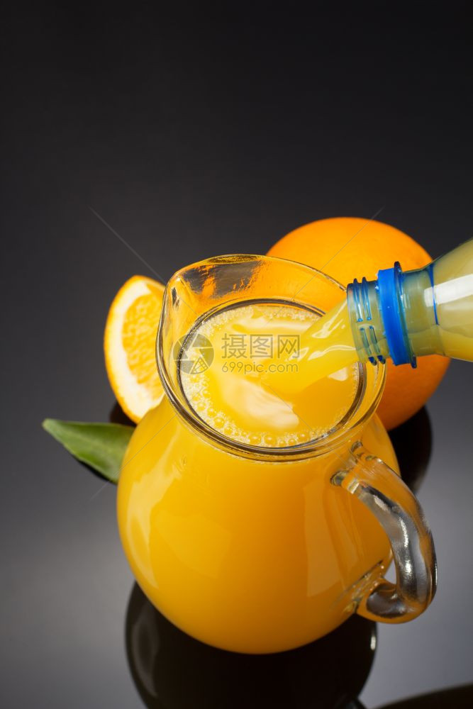 黑色背景的玻璃杯和橙汁图片