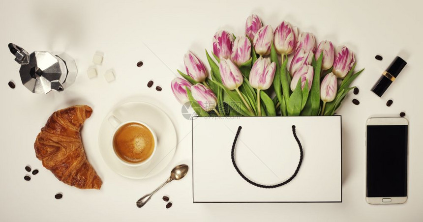 春花咖啡移动电话羊角面包和化妆品的顶端景象图片
