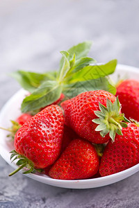 草莓在碗和桌上图片