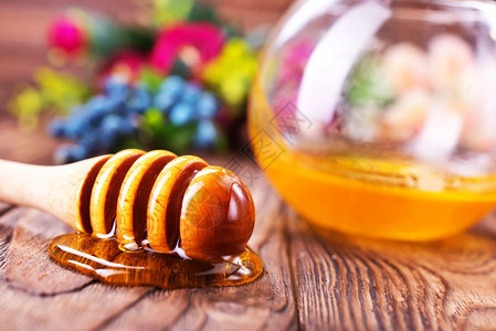 蜂蜜在玻璃碗和桌子上的蜂蜜中图片
