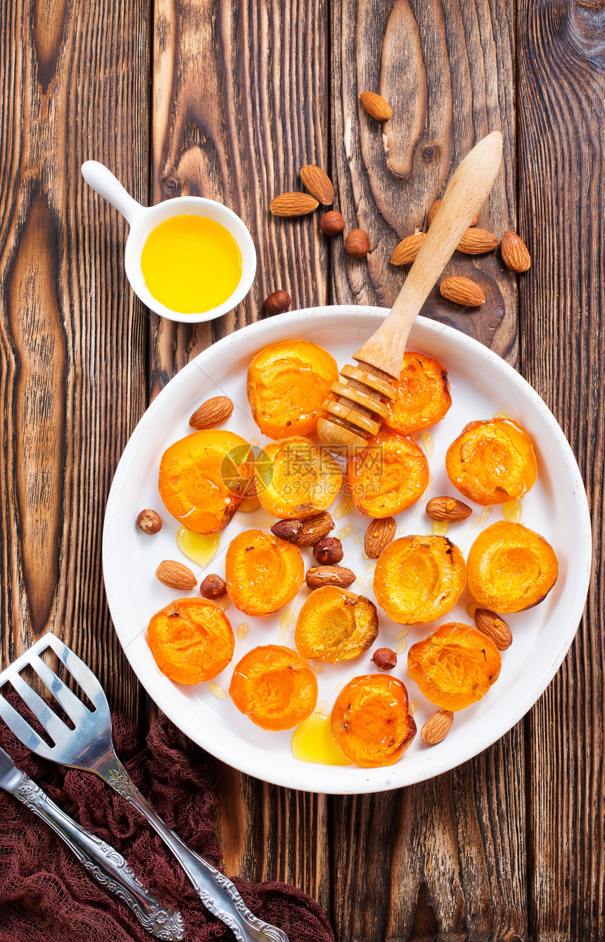 餐桌上加蜂蜜和坚果的烤杏子图片