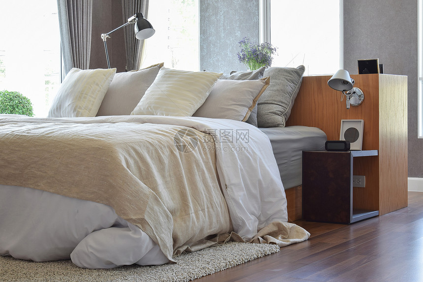 卧室内床边有白条纹枕头和装饰桌灯图片