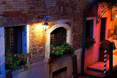 在意大利威尼斯的一栋老房子窗户上花朵夜在意大利威尼斯图片