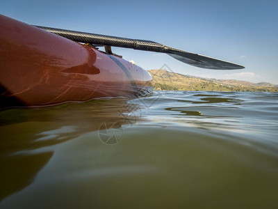 起立在水下部分拍摄的湖上拿着一个桨站在板上部分水下拍摄图片