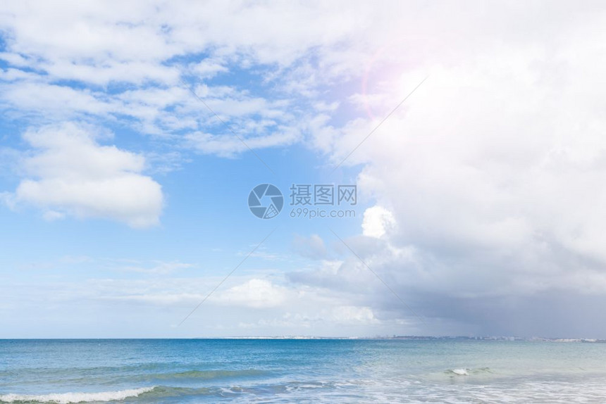 热带沙阳光的滩和蓝色云彩图片