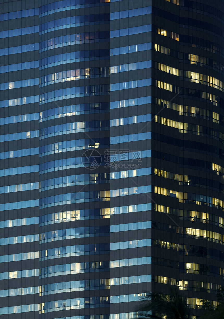 夜间照亮的办公大楼窗背景图片
