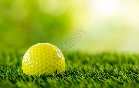 绿地上的黄高尔夫球图片