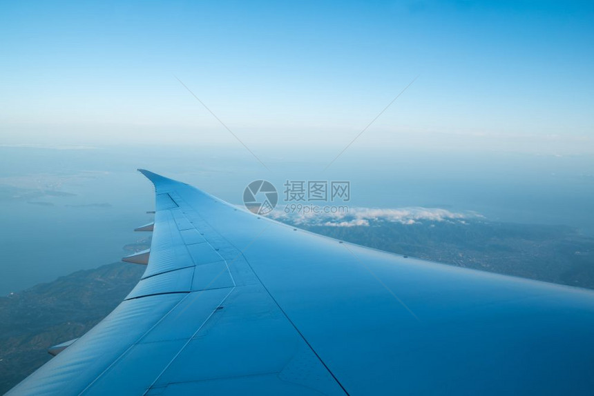 飞越海面上空的飞机机翼图片