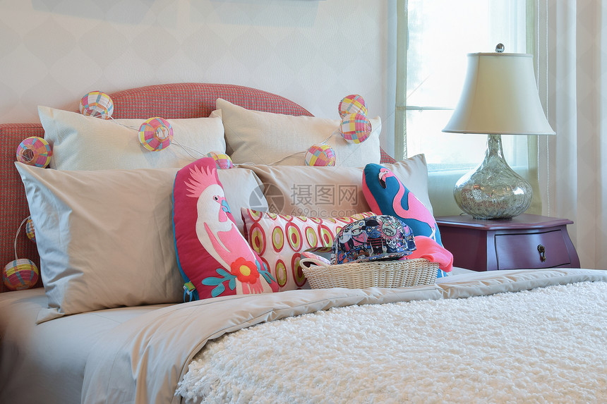 现代儿童卧室内有彩色枕头和床边桌灯图片
