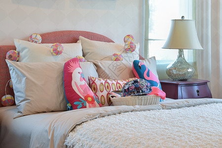 现代儿童卧室内有彩色枕头和床边桌灯图片