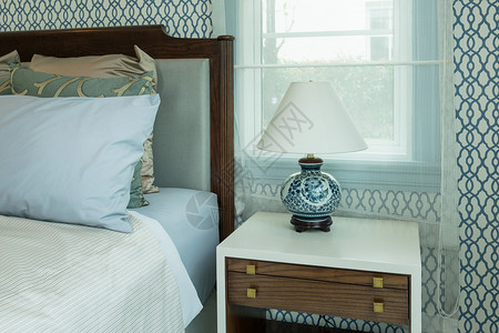 床上桌有蓝枕头和灯样式的典型卧室图片
